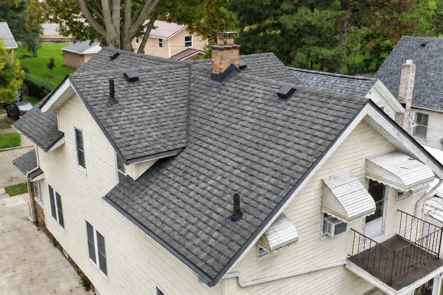 Before: a two-story home re-roofed with new architectural shingles, drone view